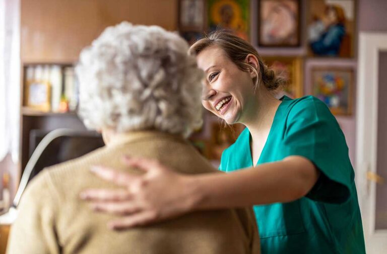 Older adult and family member reviewing care costs and documents at a kitchen table.